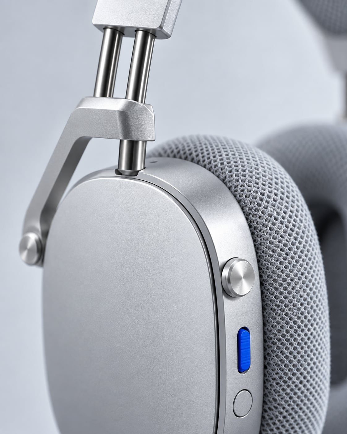 Machined aluminium yoke holding the ear cup on a pivot pin, cobalt switch beside it